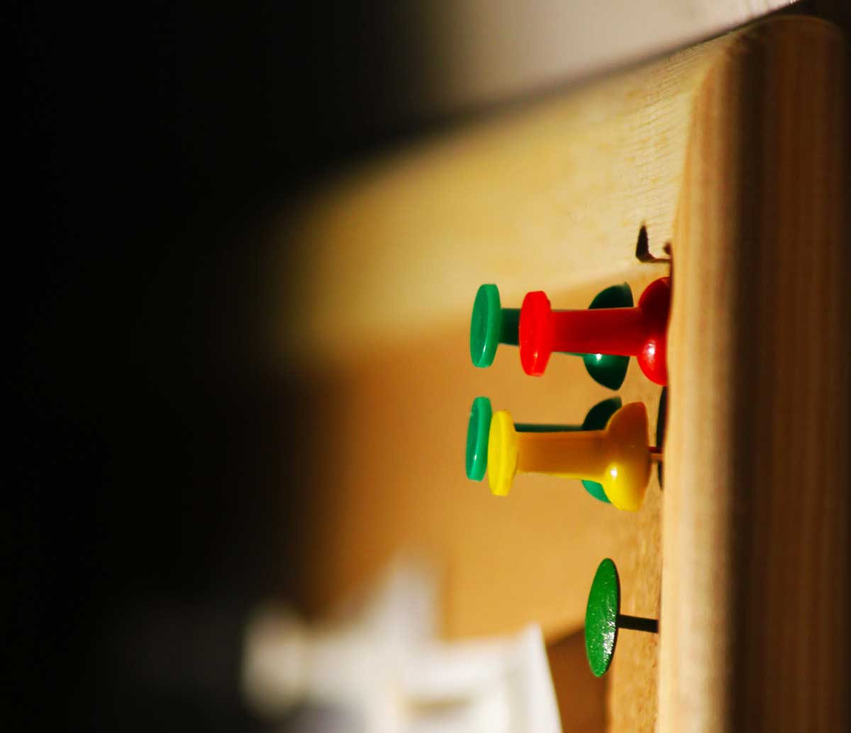 Un corcho con chinchetas de colores